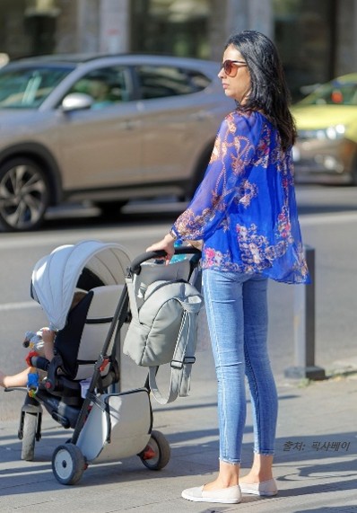 유모차를 끌고 거리로 나온 선글래스를 쓴 무심한 애기 엄마