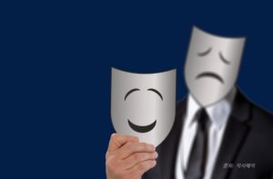 행복한 표정의 마스크를 들고 있는 불행한 얼줄의 바스크