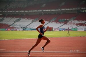 왼쪽에서 오르쪽으로 트랙을 달리는 여자 선수