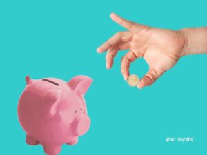 돼지저금통장에 동전을 넣은 그림