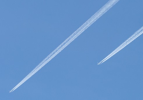 두 개의 비행기 뒤에 길게 생긴 비행운
